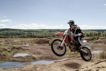 Fototapeta na wymiar dirt bike motocross rider jump on the air Alberta sand dunes
