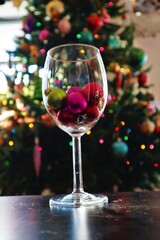 Christmas ornaments in a champagne glass with soft bokeh background