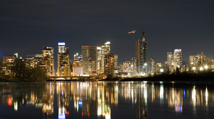 Fototapeta na wymiar Downtown office building lights reflecting on the Bow River at night in Calgary Alberta Canada.