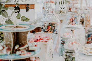 Elegantly arranged candies and sweets on a candy bar during a party, soft colors and added film grain for a vintage effect.