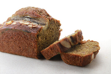 Sliced banana bread with walnuts on white background