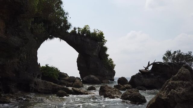 The Natural Bridge on Neil Island in the Andaman Island chain. Waves and rocks in the midday sun.