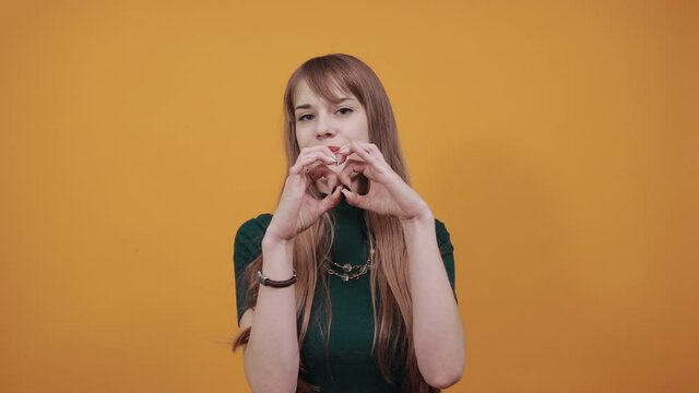 Hands shows the symbol of heart. Love to our pancreas. Pretty romantic young making a soul gesture with fingers in front chest showing feelings, affection happy tender smile.
