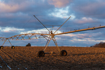 Rural sunset on a field with irrigation equipment