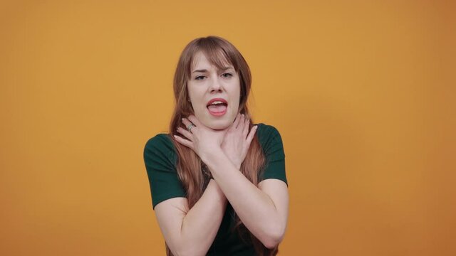 Hands around throat, screaming, panicking in trouble as chokes on food stuck and is making the official international sign for I am choking, placing fingers at neck outstretched, olive pit, asthma