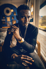 portrait of african american man holding cigar on hand in coffee shop