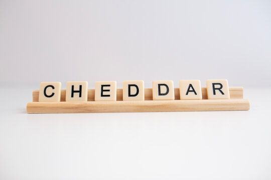 The Word Cheddar Cheese Written In Scrabble Titles Against A White Background