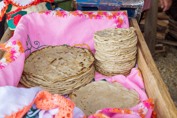A stack of traditionally cooked tortilla doughts in a wooden box