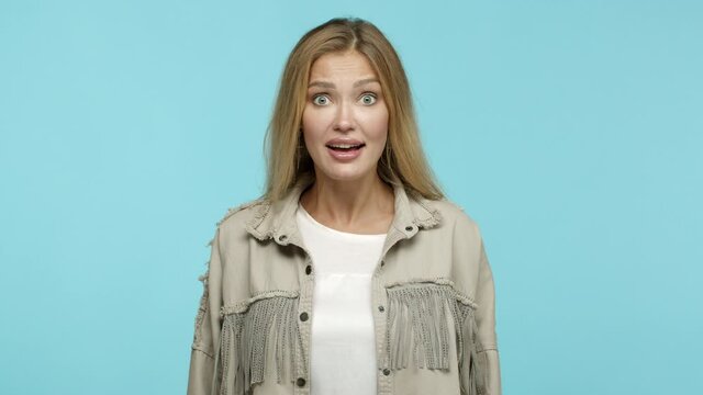 Slow motion of attractive blond woman with long hair, looking excited and saying yes, agree on deal, nod in approval, standing over blue background