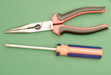 Standard workman tools isolated against a green cutting board.