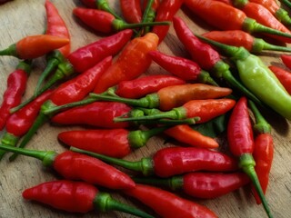 red bird's eye chilies on a wooden plank background