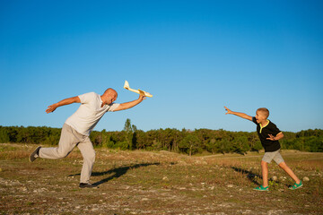 Dad and son play airplane in nature