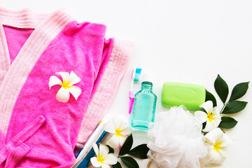 herbal soap with terry cloth health care for body skin care ,pink dressing gown cleaning to a bath and toothbrush ,mouthwash, for health care oral cavity with flower frangipani on background white