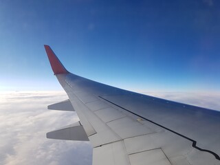 Naklejka na ściany i meble Airplane wing in blue sky