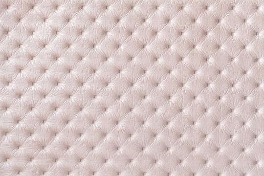 Texture of pearl beige leather background with capitone pattern, macro.