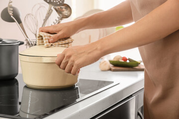 Woman with cooking pot in kitchen