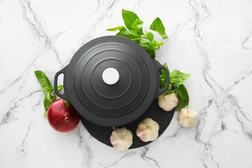 Cooking pot with vegetables on light background