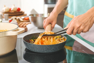 Woman cooking pasta on electric stove