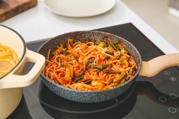 Tasty pasta with vegetables in frying pan