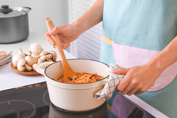 Woman cooking pasta on electric stove