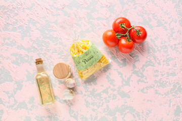 Bag with uncooked pasta, oil and tomatoes on light background
