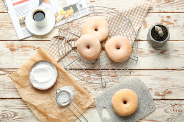 Composition with tasty donuts and cup of coffee on wooden background