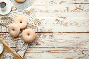 Tasty donuts and cup of coffee on wooden background
