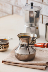 Cezve and cups of coffee on table