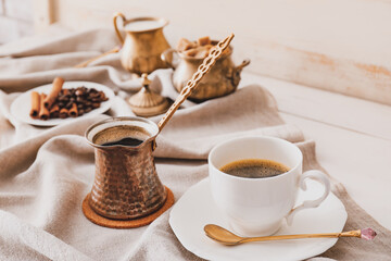 Cezve, cup of coffee, sugar and milk  on table
