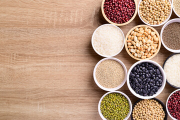Obraz na płótnie Canvas Various cereal grain in a bowl on wooden background (quinoa seeds, black kidney bean, peanut, perilla seeds, soybean, azuki beans, rice grain and mung beans)