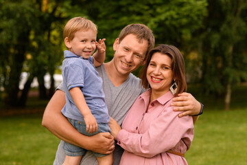 Fototapeta premium Happy young family spending time together, outside, on vacation, outdoors. The concept of family holiday.