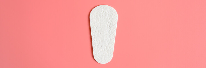 one pure empty women's disposable daily menstrual sanitary pad or napkin on pink background. banner