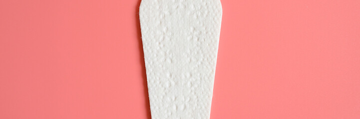 one pure empty women's disposable daily menstrual sanitary pad or napkin on pink background. banner