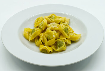 Tortelloni with ricotta, sage and Parmigiano Reggiano cheese, isolated on white background. Traditional italian pasta. 