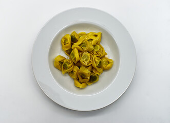 Tortelloni with ricotta, sage and Parmigiano Reggiano cheese, isolated on white background. Traditional italian pasta. 