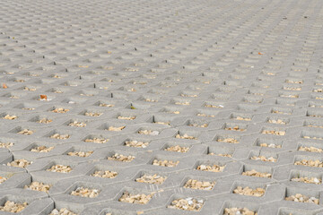 geometric concrete tile with holes. Covering for car parking. the holes are filled with small stones