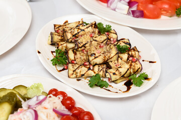 eggplant rolls with cream sauce on a white plate on a festive table