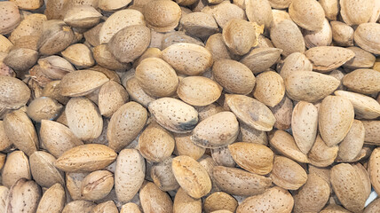 Fototapeta na wymiar brown many almonds in background in market for sale