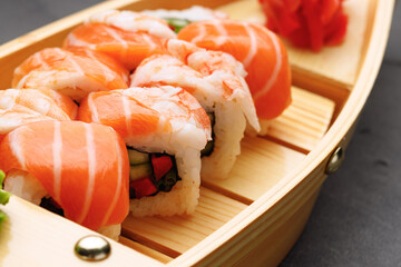 Sushi roll covered with salmon and prawn close up