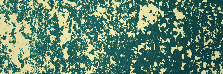 Peeling paint on the wall. Panorama of a concrete wall with old cracked flaking paint. Weathered rough painted surface with patterns of cracks and peeling. Wide panoramic grungy texture for background
