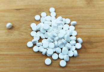 calcium pills on wooden background