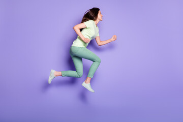 Fototapeta na wymiar Photo portrait full body view of active girl running forward jumping up isolated on vivid purple colored background