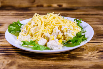 Festive salad with chicken breast, canned pineapple, cheese, sweet corn and mayonnaise on wooden table