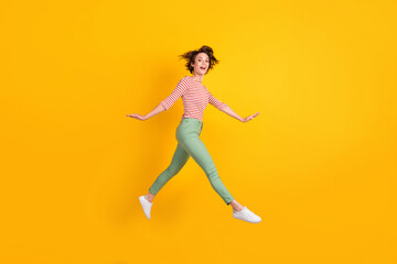 Fototapeta na wymiar Full length body size profile side view of lovely cheery girl jumping going isolated over bright yellow color background