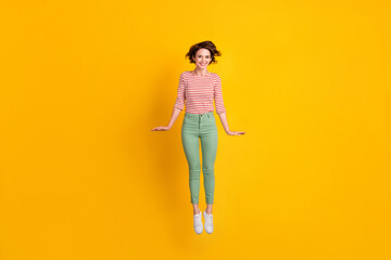 Full body photo of pretty nice young person jumping have fun isolated on bright yellow color background