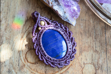 Lapis lazuli gemstone macrame pendant on natural background