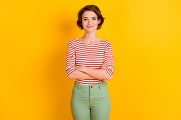 Photo of content positive person crossed arms look camera isolated on vibrant yellow color background