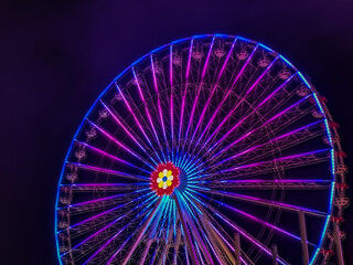 illuminated big wheel with gondolas in a amusement park