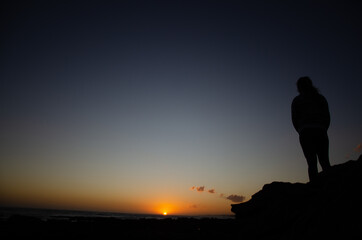 silhouette of a person standing on a rock
