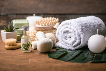 Wellness decoration, spa massage setting,  oil on wooden background. Spa, Zen and relax concept. Spa treatment concept. Natural, Organic spa cosmetics products, sea salt, massage brush. Spa background